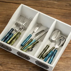Stainless steel cutlery set with bamboo handles, featuring steak knives, dinner forks, and spoons.