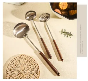 Detail view of stainless steel kitchen utensil set with wooden handles in kitchen scene.