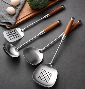 Stainless steel kitchen utensil set detail showing wooden handle spatula and ladle on grey surface.