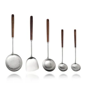 Stainless steel kitchen utensil set with walnut handles including spatula and spoons.