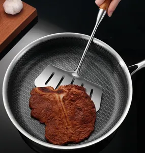 Stainless steel slotted spatula with wooden handle for easy flipping and cooking.