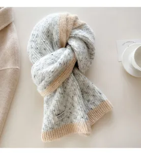 Detail view of the cozy wool-blend flecked knit scarf in chic color block style for winter.