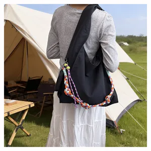 Vista dettagliata della borsa a tracolla in nylon nero con decorazione in corda intrecciata.
