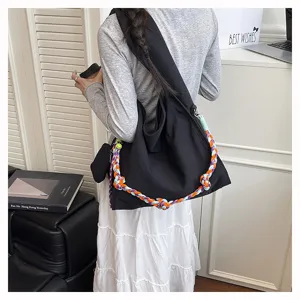 Borsa a tracolla nera in nylon di grande capacità con tracolla intrecciata colorata.