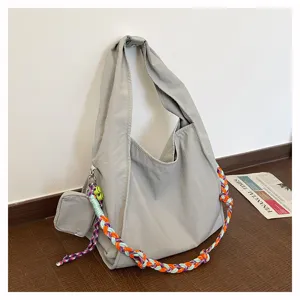 Borsa a tracolla morbida in nylon grigio con tracolla intrecciata colorata e dettaglio.