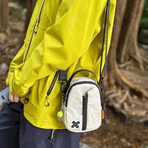 Casual outdoor small crossbody shoulder bag worn by person, urban commuter daily phone bag.