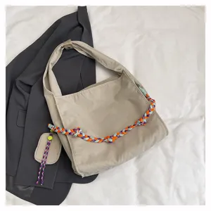 Vista dettagliata della borsa a tracolla in nylon, borsa beige casual con tracolla intrecciata.