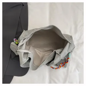 Vista dettagliata dell'interno della borsa a tracolla in nylon e manico intrecciato