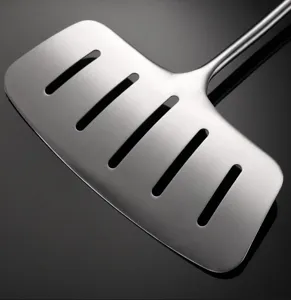 High quality stainless steel slotted fish turner spatula close-up detail shot for cooking.