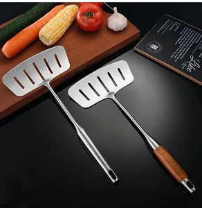 Stainless steel spatula detail showing wide slotted face and comfortable wooden handle.