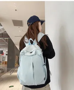 Backpack detail view showing the light blue fabric, front zipper pocket, and side strap.