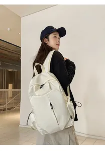 Minimalist white canvas backpack with spacious main compartment, ideal for daily commute.