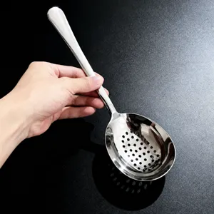 Vue détaillée de la cuillère écumoire en acier inoxydable montrant la tête perforée.
