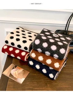 Detailed view of cozy wool-blend polka dot knit scarf stack, showcasing soft winter texture.
