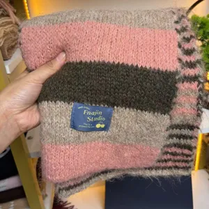 Detailed shot of knitted striped winter scarf, showing wool blend texture and cozy thick design.