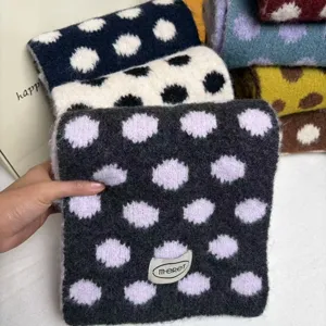 Detailed view of winter wool-blend knitted scarf with large polka dot pattern and cozy knit.