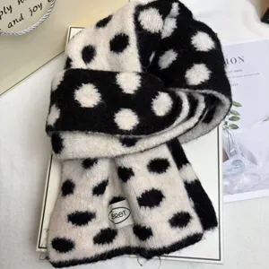 Close-up of black and white polka dot knitted wool scarf detail, cozy and warm for winter.