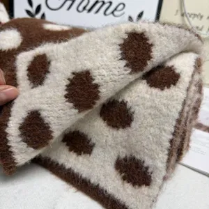 Detail shot of cozy wool blend polka dot knitted scarf texture, soft winter warm accessory.