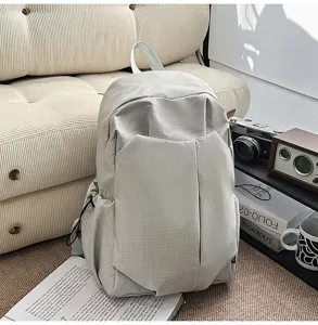 Detailed view of the stylish grey gridded backpack, showing fabric texture and design.