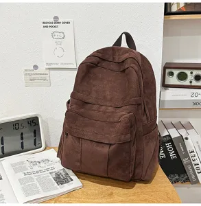 Detailansicht des braunen Vintage-Wildleder-Rucksacks mit mehreren Taschen und Struktur.
