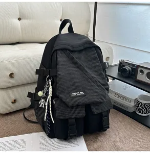 Detailed view of casual tool-style student backpack, black plaid pocket design with astronaut charm.