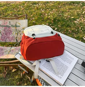 Detailed view of stylish color-blocking student backpack in outdoor camping setting.