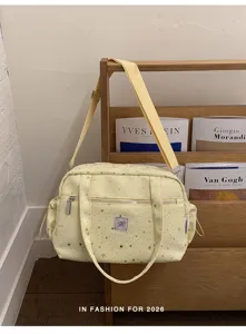 Yellow canvas shoulder bag detail, silver star print, daily commuter style, practical storage.