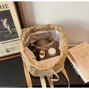 Detailed view of khaki drawstring backpack interior storage capacity and lining design.