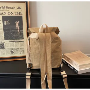 Detail shot of khaki minimalist drawstring backpack, showing straps, zippers and texture.