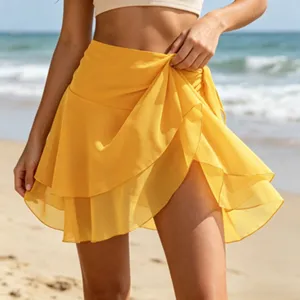 Nahaufnahme des gelben Chiffon-Strandrocks mit Lagen-Rüschen im schicken Urlaubslook am Meer.