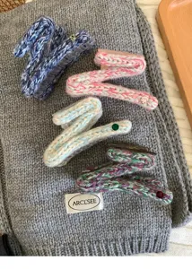 Détail de pince à cheveux en tricot épais, accessoire griffe en laine pour cheveux épais.