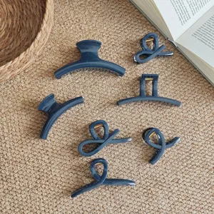 Detailed shot of dark blue hair claw clips set, various chic twisted shapes for thick hair.