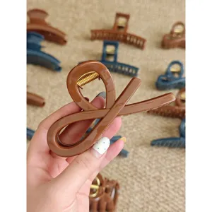 Brown cross hair claw clip detail, elegant hair accessory for thick hair, daily styling tool.