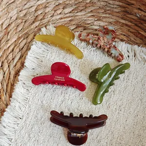 Detailed shot of Korean style acetate hair claw clips in various chic colors and marbled patterns.