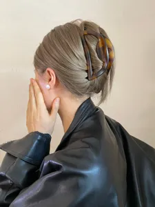 Detail view of a Korean retro tortoiseshell hair claw clip with a hollow semi-circular design.