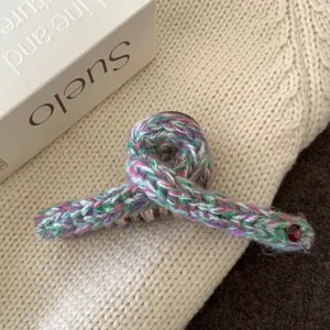Vue détaillée d'une pince à cheveux tricotée multicolore confortable, design croisé chic.