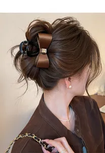 Rhinestone bow hair claw clip for women, elegant back head hair styling accessory.