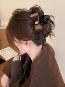 Elegant brown satin bow hair claw clip with rhinestone, chic updo hair accessory for women.