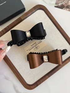 Elegant satin bow hair claw clip with sparkly rhinestone, perfect for chic hair styling.