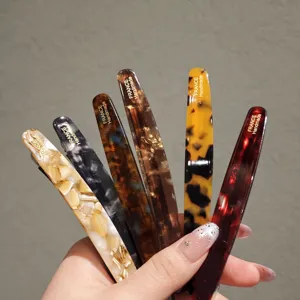 Detailed close-up of colorful acetate hair clips, premium tortoise shell pattern design.