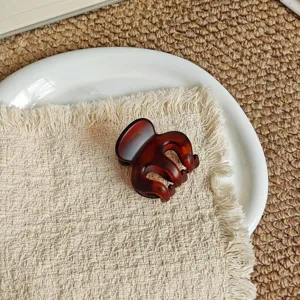 Tortoiseshell hair claw clip detail, minimalist elegant hair accessory for daily styling.