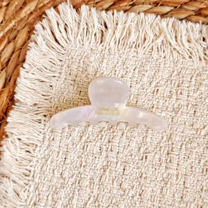 Detail view of a pearlescent white acetate hair claw clip, elegant and chic hair accessory.