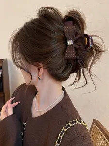 Élégante pince à cheveux marron avec nœud à pois chic et détail en strass étincelant.