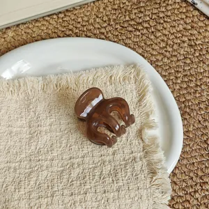 Elegant brown hair claw clip for women, mini resin hair accessory for chic buns and ponytails.