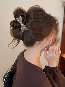 Elegant iridescent bow hair claw clip detail shot, perfect for stylish updos and daily wear.