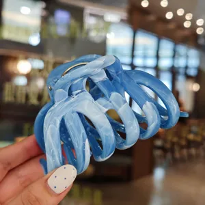 Close-up detail view of the blue marbled hair claw clip, featuring elegant resin texture.