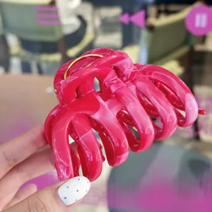 Detailed close-up of a stylish pink marble-textured hair claw clip, perfect for thick hair.
