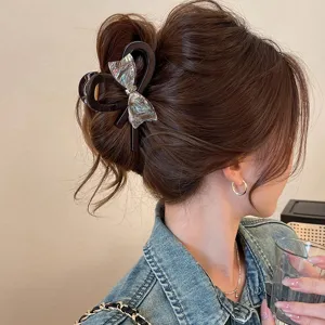Elegant iridescent bow hair claw clip for women, stylish large shark clip for thick hair styling.
