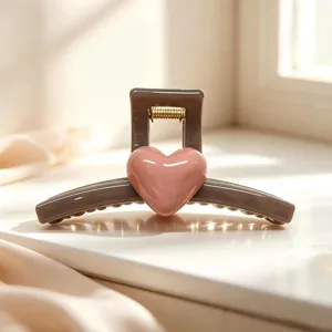 Detail view of the elegant grey hair claw clip featuring a glossy pink heart accent and spring.