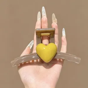Detail view of brown hair claw clip with yellow heart charm, premium shark clip for thick hair styling.